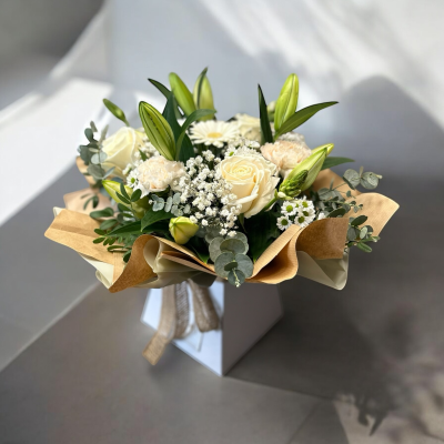 Evelyn - We are pleased to introduce this stunning box arrangement, made in floral foam for easy care, this bouquet is made with pure white lilies and roses with a mix of seasonal blooms an