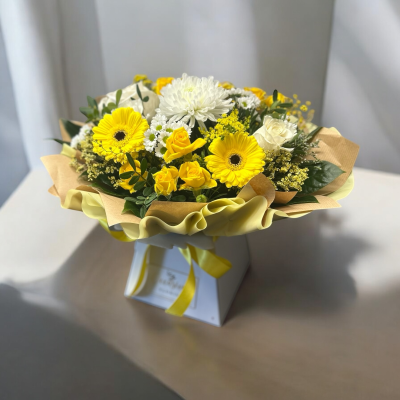 Summer Sunshine - We are pleased to introduce this beautiful box arrangement which is guaranteed to brighten anyone's day, Made with yellow and white seasonal blooms with lush greenery in floral foa